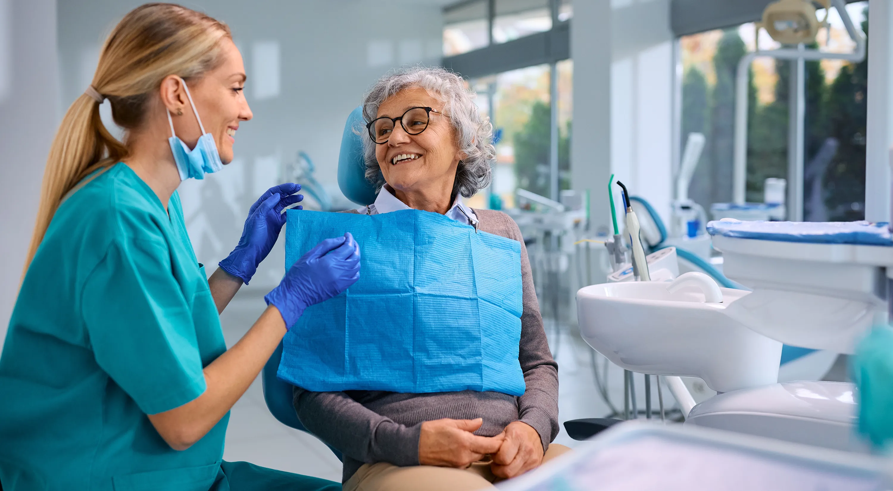 An older woman talking with the dentist.