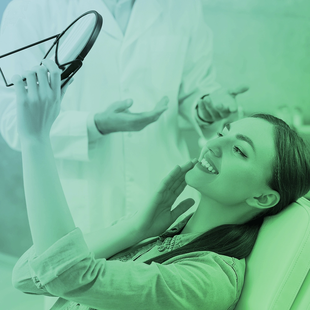 A woman at the dentist looking at herself in the mirror.
