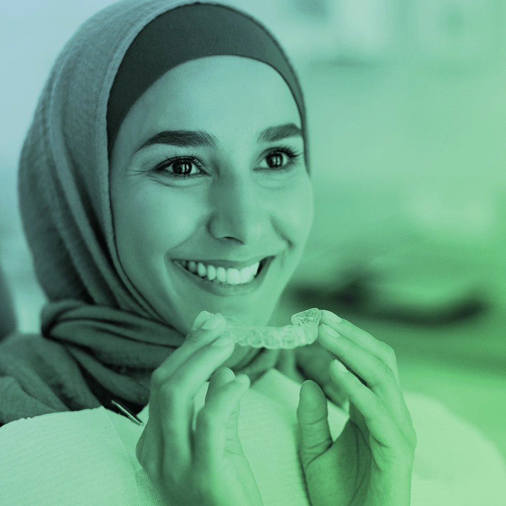 A woman holding invisaligns.